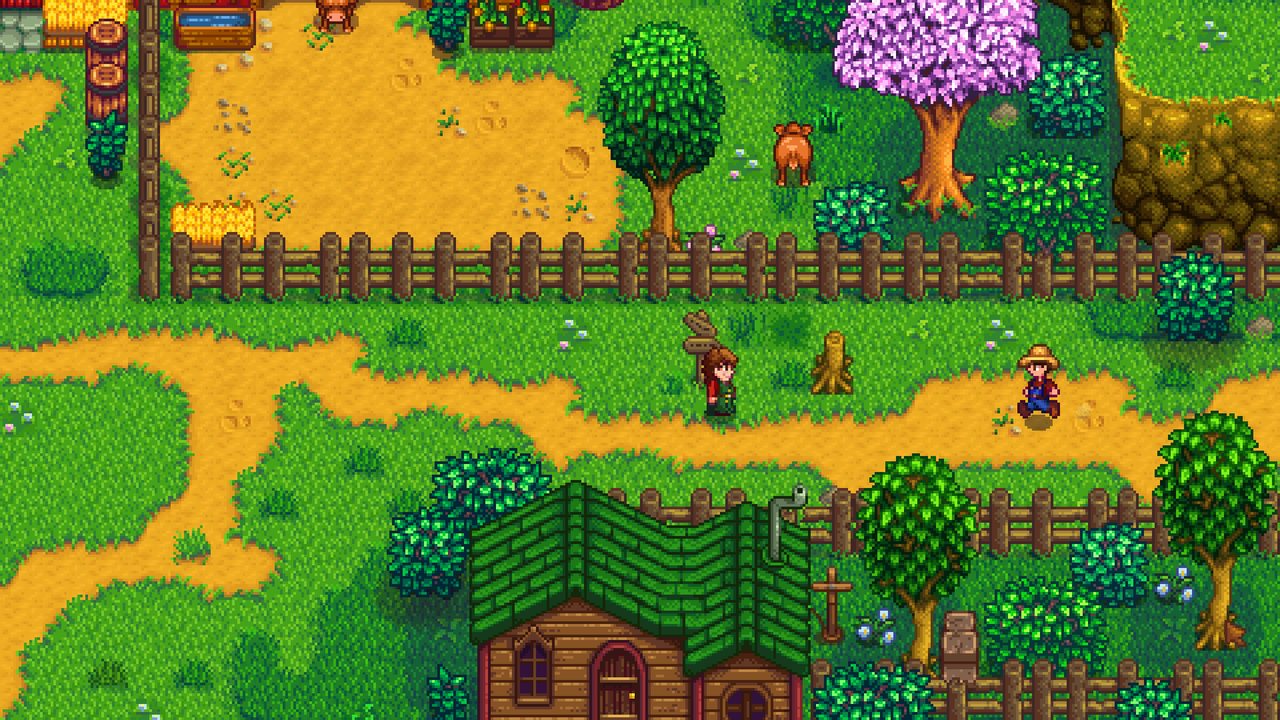 A farm with fenced crops and a red barn